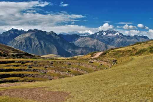 Ancient circular terraces of Moray unfold beneath snow-capped Andean peaks in the Sacred Valley. 