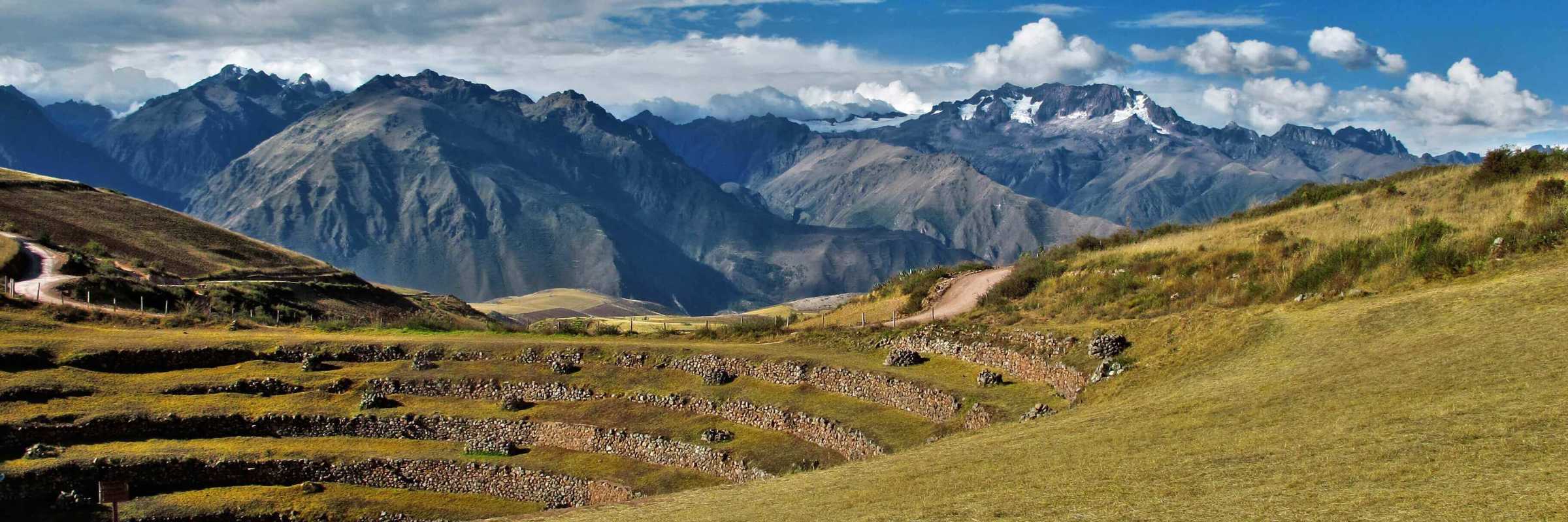 Ancient circular terraces of Moray unfold beneath snow-capped Andean peaks in the Sacred Valley. 