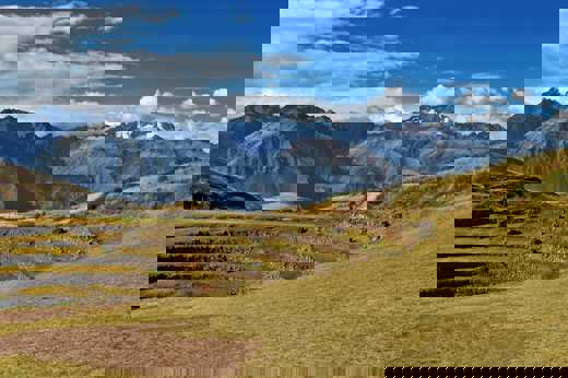 Ancient circular terraces of Moray unfold beneath snow-capped Andean peaks in the Sacred Valley. 