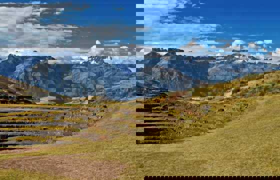 Ancient circular terraces of Moray unfold beneath snow-capped Andean peaks in the Sacred Valley. 