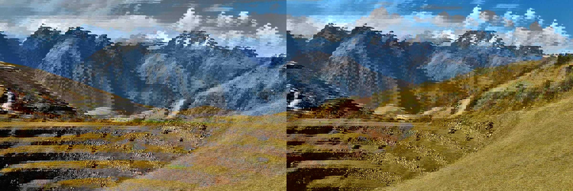 Ancient circular terraces of Moray unfold beneath snow-capped Andean peaks in the Sacred Valley. 