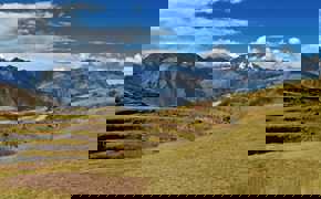 Ancient circular terraces of Moray unfold beneath snow-capped Andean peaks in the Sacred Valley.