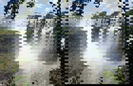 Panoramic view of Iguazu Falls surrounded by lush rainforest.