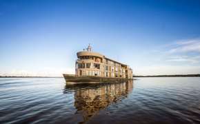 The Delfin III glides over glassy Amazon waters, offering luxury and adventure deep in the jungle. 