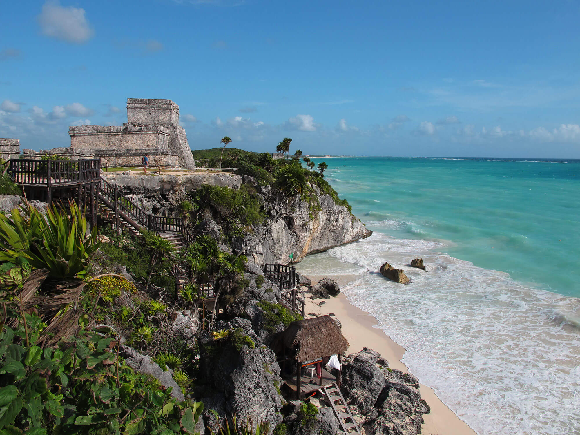 Ancient Tulum ruins on a cliff above the Caribbean Sea, Yucatan Peninsula, Mexico, with turquoise waters and blue sky. 