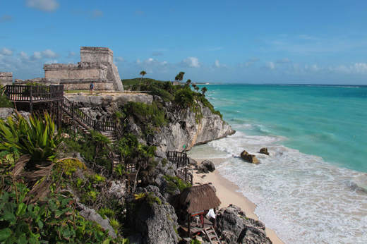 Ancient Tulum ruins on a cliff above the Caribbean Sea, Yucatan Peninsula, Mexico, with turquoise waters and blue sky. 