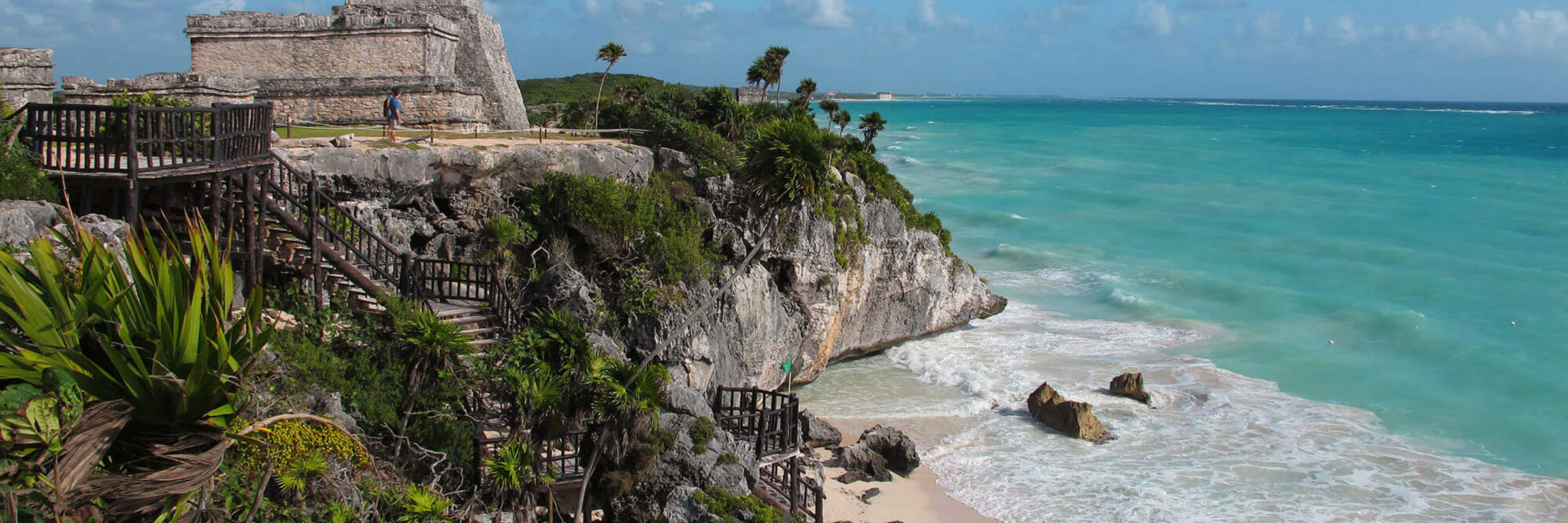 Ancient Tulum ruins on a cliff above the Caribbean Sea, Yucatan Peninsula, Mexico, with turquoise waters and blue sky. 