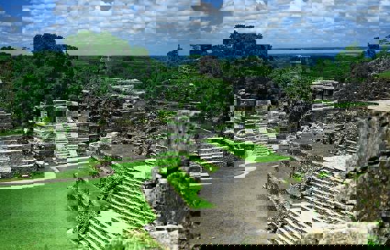 View of the ancient Mayan temples and ruins at Palenque, surrounded by jungle in Chiapas, Mexico.