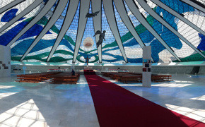 Interior of the Cathedral of Brasilia, showcasing stained glass ceiling and suspended angel sculptures in modernist design.