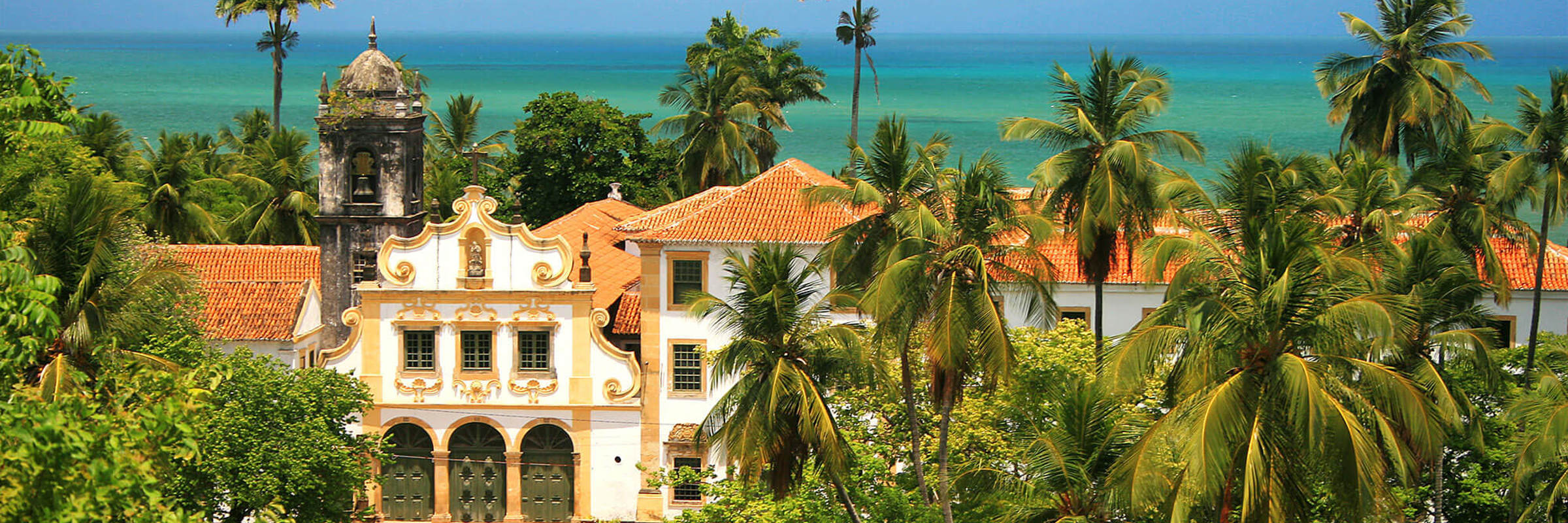View of colonial architecture, church towers, and palm trees in Olinda overlooking the Atlantic coast near Recife, Brazil. 