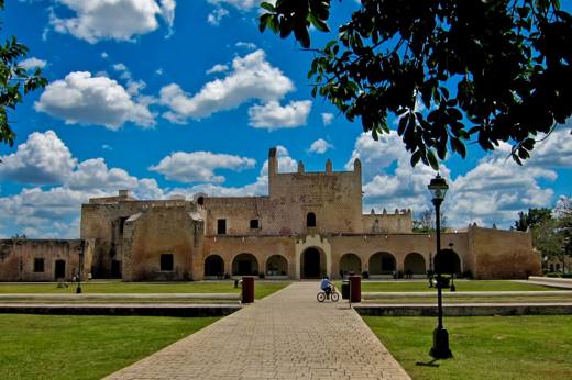 Colonial-era Convento de San Bernardino in Valladolid, Yucatan, framed by a bright sky and well-kept gardens. 