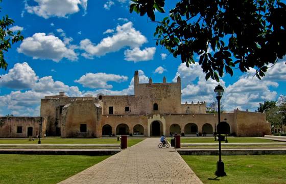 Colonial-era Convento de San Bernardino in Valladolid, Yucatan, framed by a bright sky and well-kept gardens. 