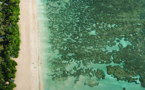 Aerial view of the turquoise sea, coral reef, and tropical shoreline at Morro de Sao Paulo, Bahia, Brazil.