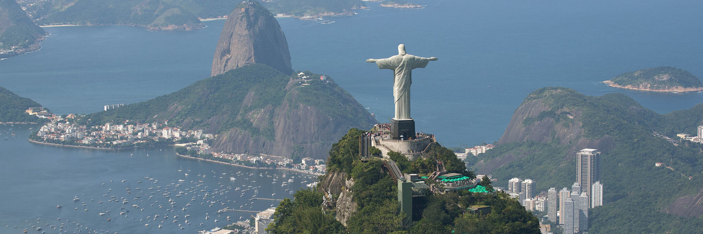 Christ the redeemer overlooks Rio and Sugarloaf Mountain on Brazil's coastline. 