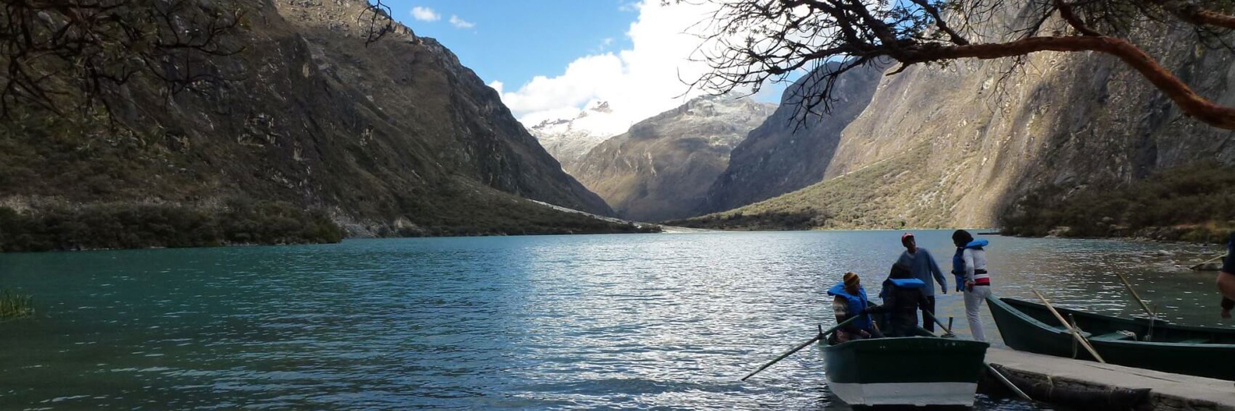 Scenic lake in Huaraz with mountains and boat under a clear sky in the Peruvian Andes. 