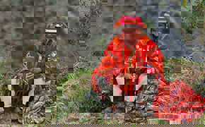 A local man in vibrant Andean dress plays a flute, embodying the spirit and culture of Peru's Sacred Valley.