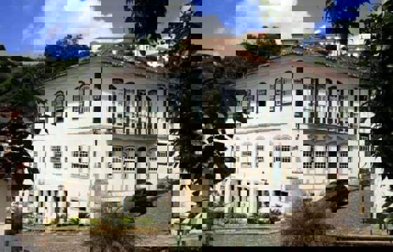 Historic white colonial building housing the Luxor Pousada in Ouro Preto, Minas Gerais, Brazil.