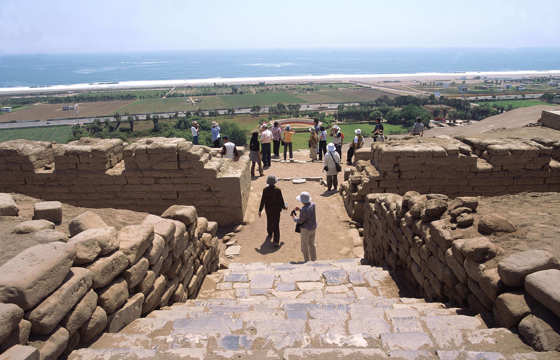 Visitors descend Pachacamac's ancient stone steps with sweeping views to the Pacific beyond.