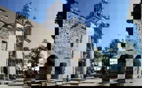 Elegant colonial church in Mexico with stone facade and baroque towers, standing beneath a clear blue sky. 
