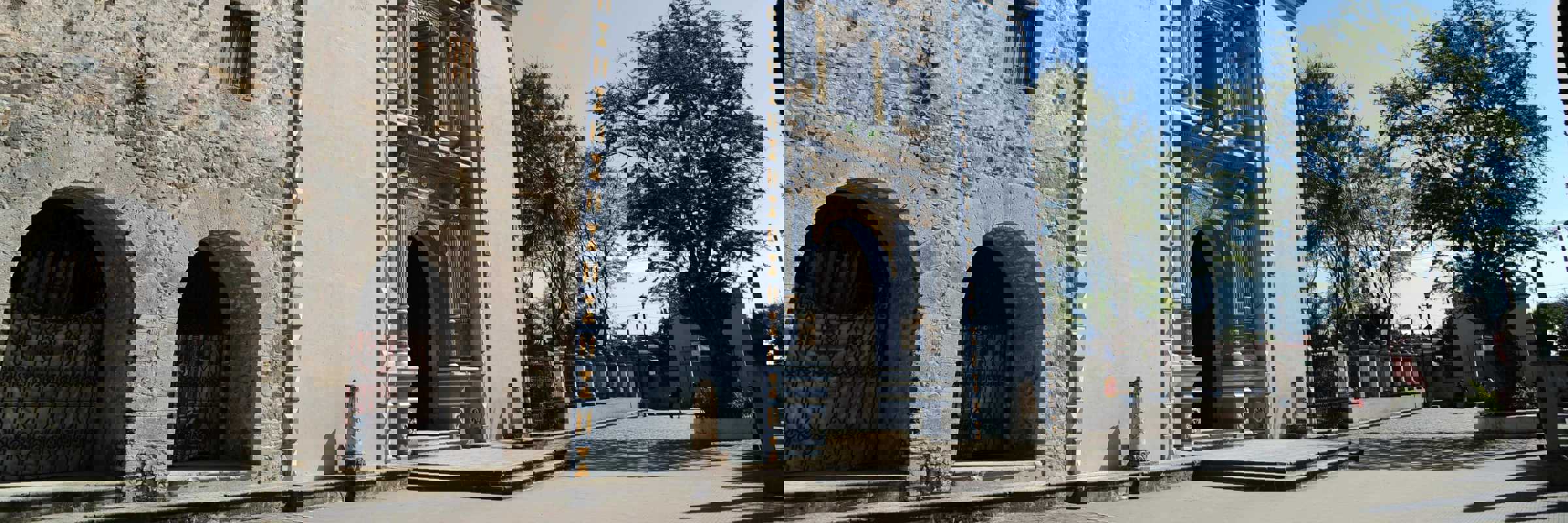 Elegant colonial church in Mexico with stone facade and baroque towers, standing beneath a clear blue sky. 