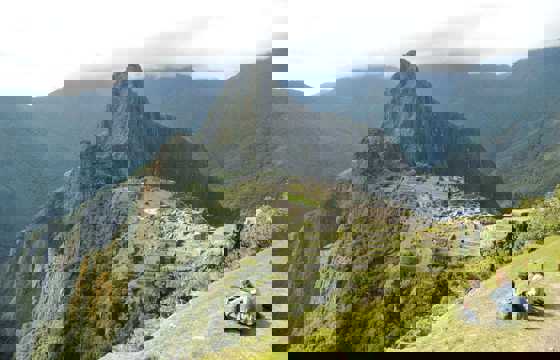 Panoramic view of Machu Picchu with Inca ruins and Huayna Picchu mountain in the background.