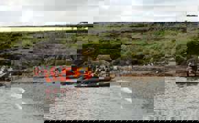 Zodiac landing near a penguin colony on the wild, green shores of southern Chile. 