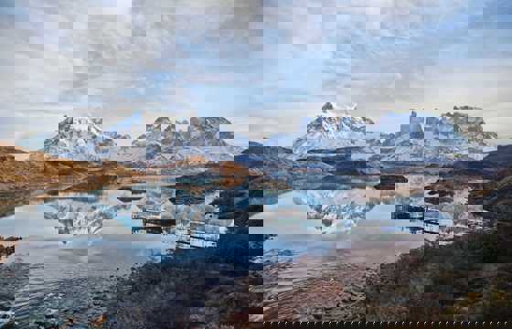Cyrstal-clear Pehoe Lake reflects the jagged peaks of Torres del Paine, Chile. 