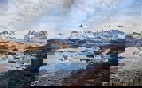 Cyrstal-clear Pehoe Lake reflects the jagged peaks of Torres del Paine, Chile.