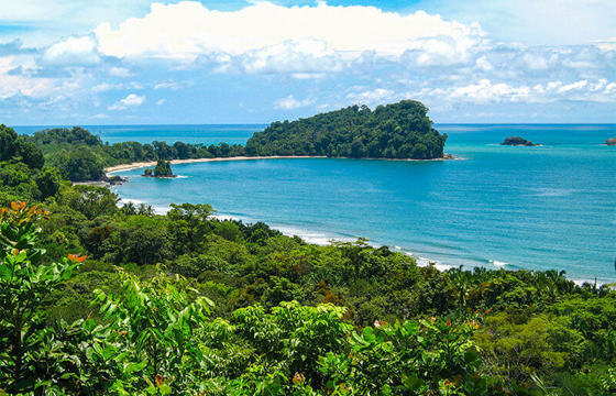 Tropical coastal view from Manuel Antonio National Park, with forested hills and turquoise Pacific waters. 
