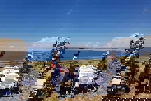 Private picnic setup with panoramic views of Lake Titicaca in the Peruvian highlands. 