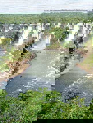 Iguassu Falls thunders through Brazil's rainforest in a sweeping panoramic view.