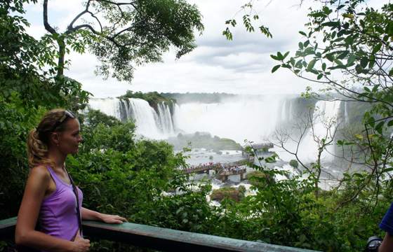 Viewpoint over Iguassu Falls in Brazil, framed by tropical rainforest and mist. 