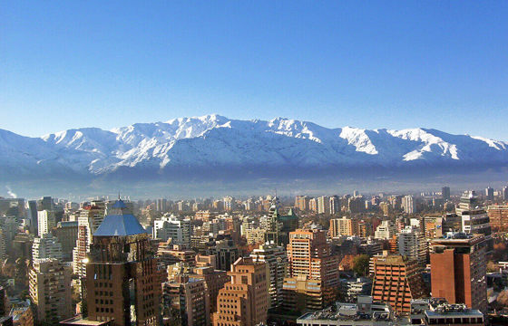 Snow-covered Andes towering above Santiago's urban skyline on a crisp winter day in central Chile.