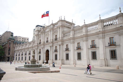 The grand facade of La Moneda Palace, the presidential seat of Chile, located in the heart of Santiago with the Chilean flag. 