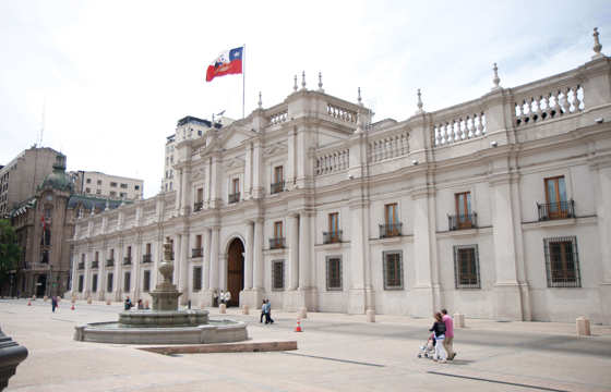 The grand facade of La Moneda Palace, the presidential seat of Chile, located in the heart of Santiago with the Chilean flag.