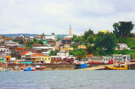 Colorful houses line the harbor of Castro on Chiloe Island, Chile, showcasing the island's iconic coastal charm and fishing culture. 