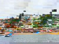 Colorful houses line the harbor of Castro on Chiloe Island, Chile, showcasing the island's iconic coastal charm and fishing culture. 