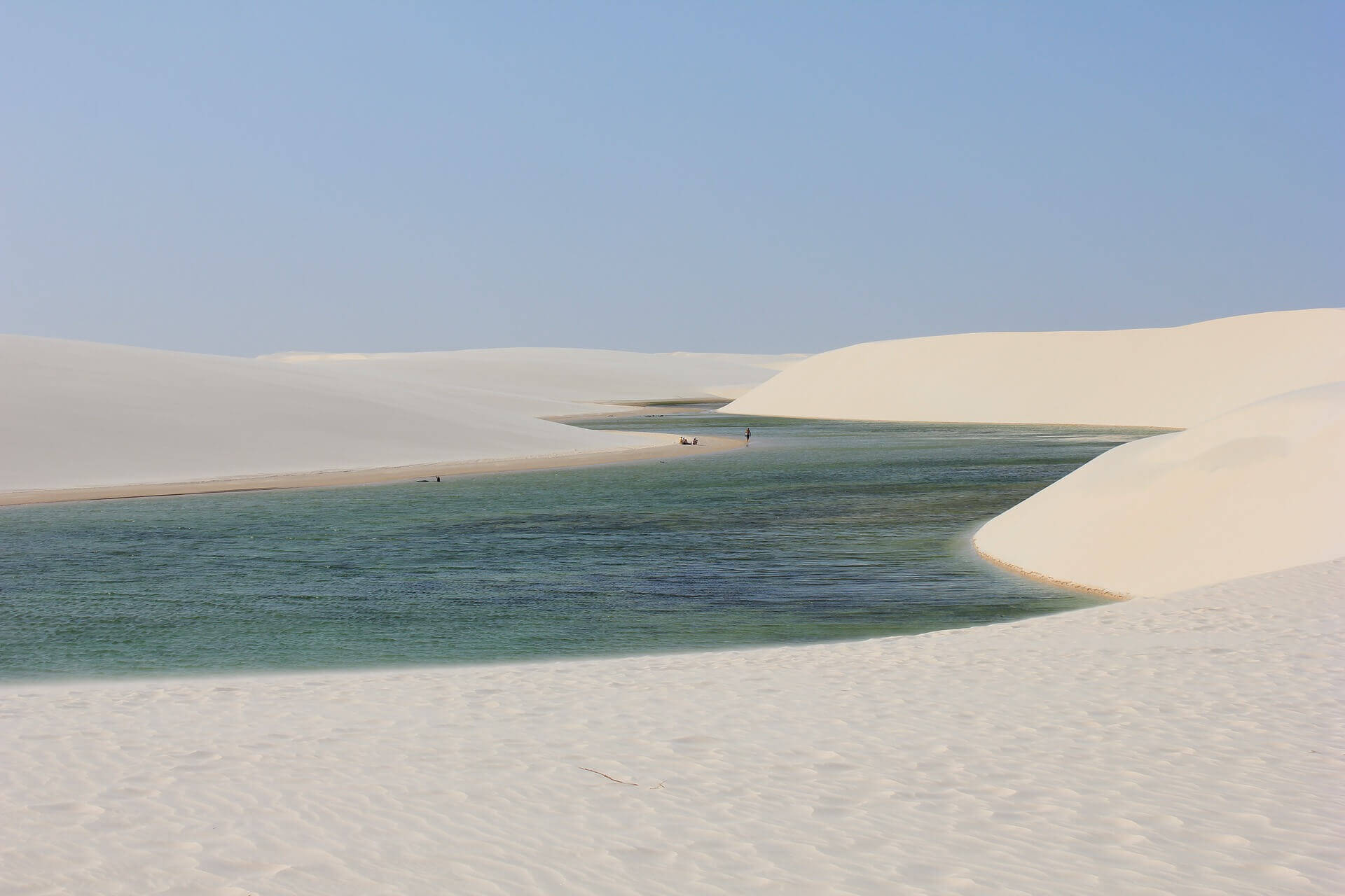 Stunning view of the white sand dunes and a turquoise rainwater lagoon at Lencois Maranhenses National Park, Maranhao, Brazil. 