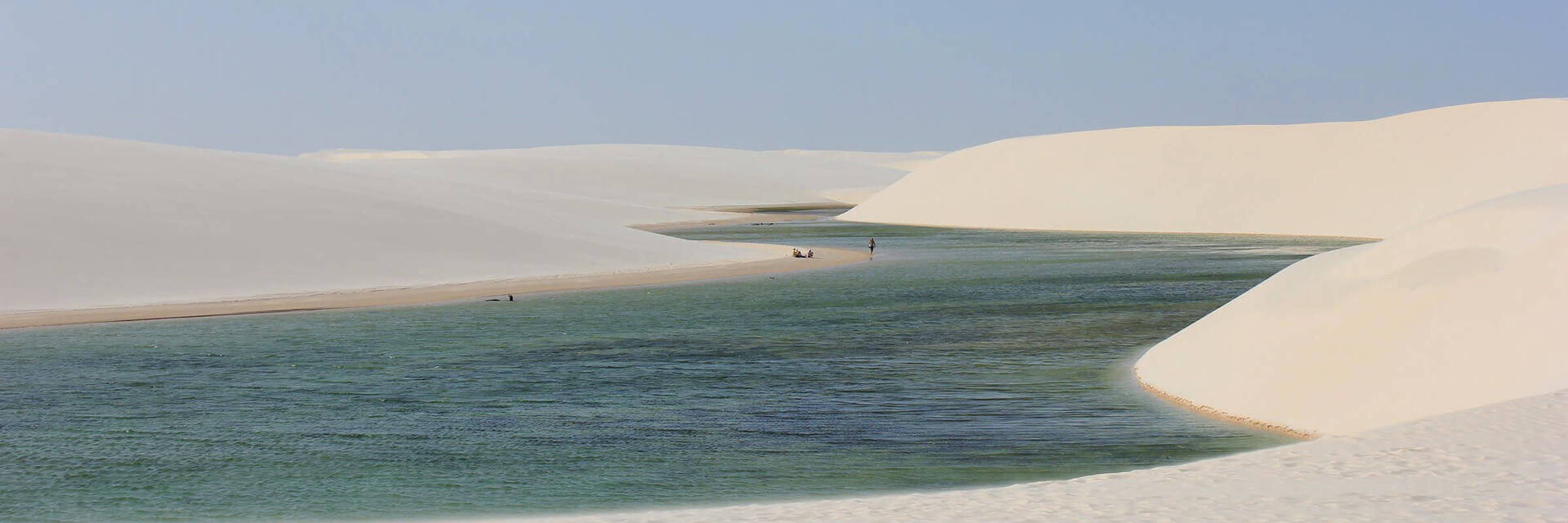 Stunning view of the white sand dunes and a turquoise rainwater lagoon at Lencois Maranhenses National Park, Maranhao, Brazil. 