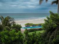 Tropical palms frame serene ocean waves at Kichic's peaceful beachfront hideaway in Mancora. 