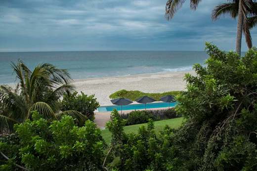 Tropical palms frame serene ocean waves at Kichic's peaceful beachfront hideaway in Mancora. 