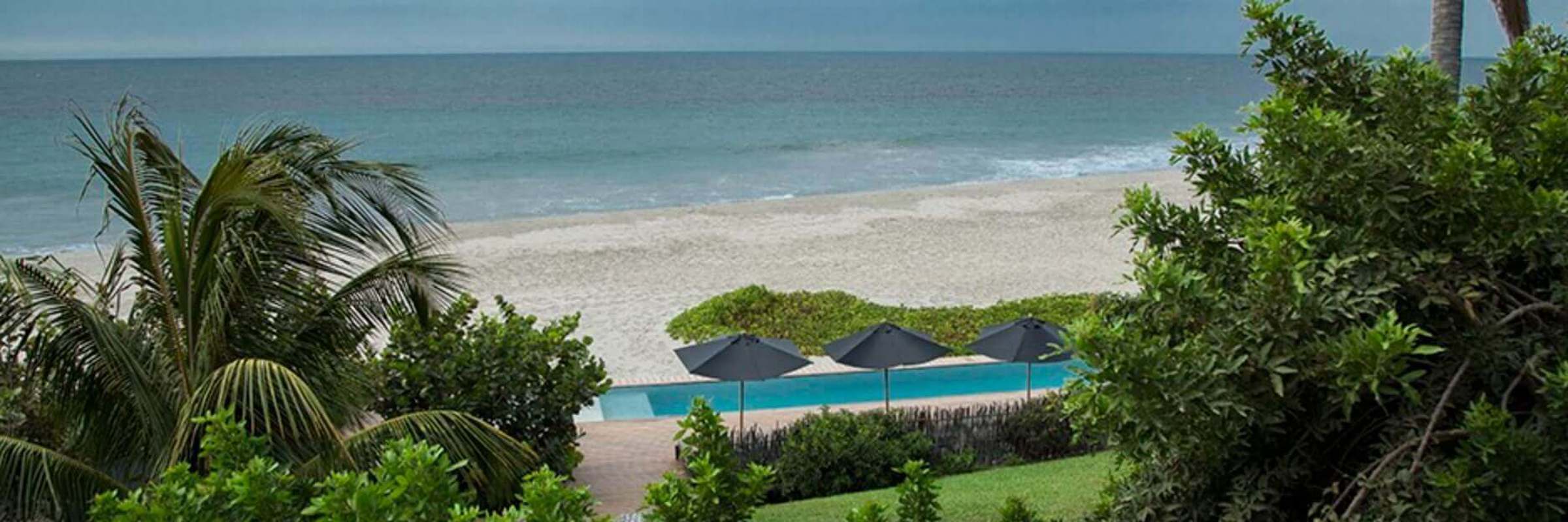 Tropical palms frame serene ocean waves at Kichic's peaceful beachfront hideaway in Mancora. 