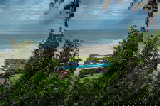 Tropical palms frame serene ocean waves at Kichic's peaceful beachfront hideaway in Mancora. 