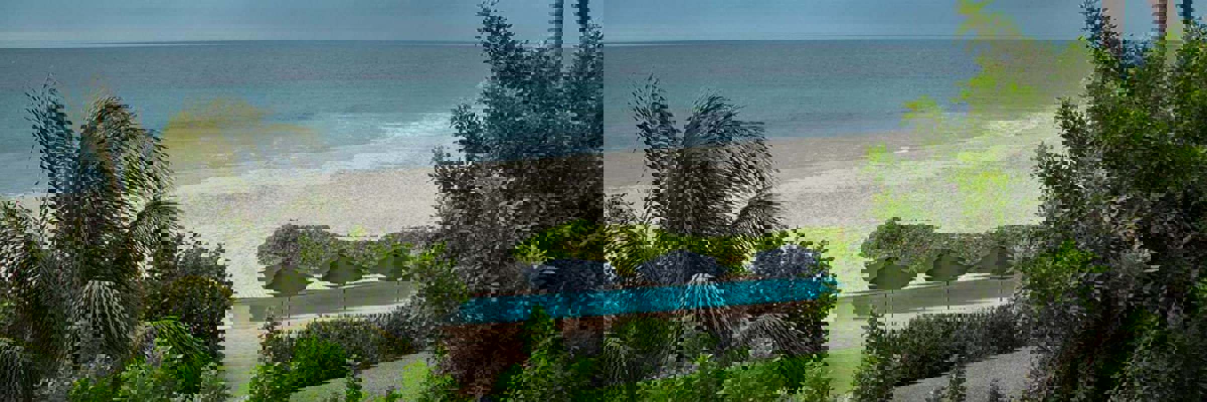 Tropical palms frame serene ocean waves at Kichic's peaceful beachfront hideaway in Mancora. 