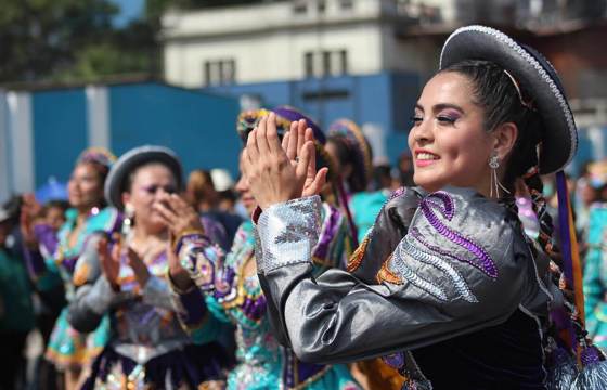Smiling Peruvian women in traditional dress performing a folkloric dance in Lima. 