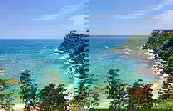 Scenic view of Puerto Escondido's Pacific coastline in Mexico with turquoise waters, sandy beaches, and lush greenery.