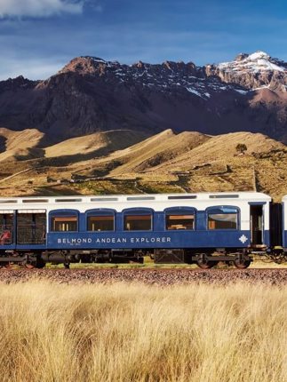 The Belmond Andean Explorer train crossing the high plans of Peru with the Andes in the background. 