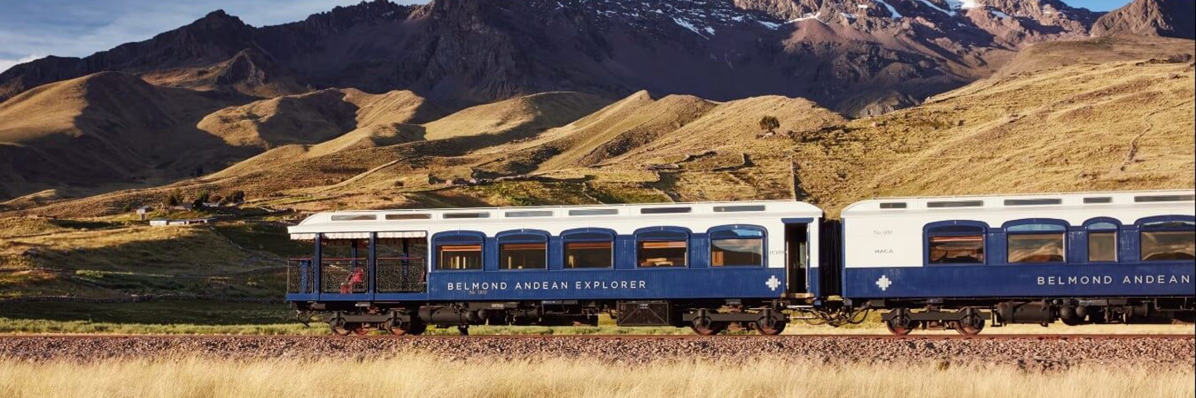 The Belmond Andean Explorer train crossing the high plans of Peru with the Andes in the background. 