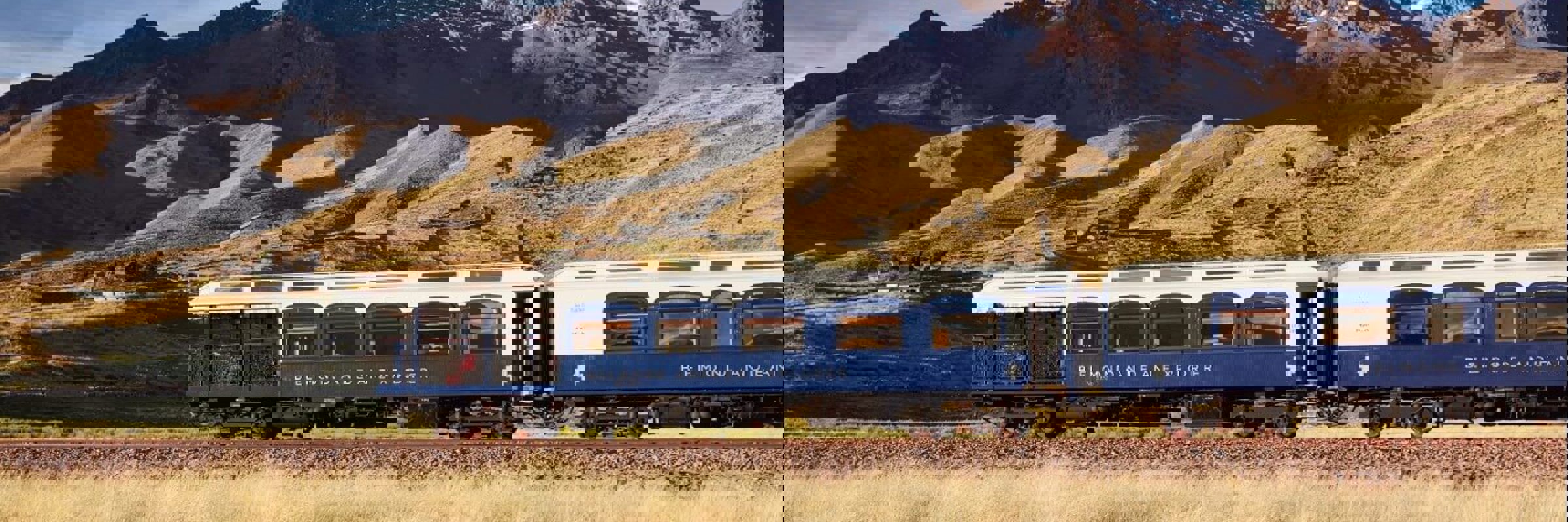 The Belmond Andean Explorer train crossing the high plans of Peru with the Andes in the background. 