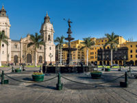 Historic Cathedral of Lima and Plaza de Armas with colonial architecture and palm trees. 